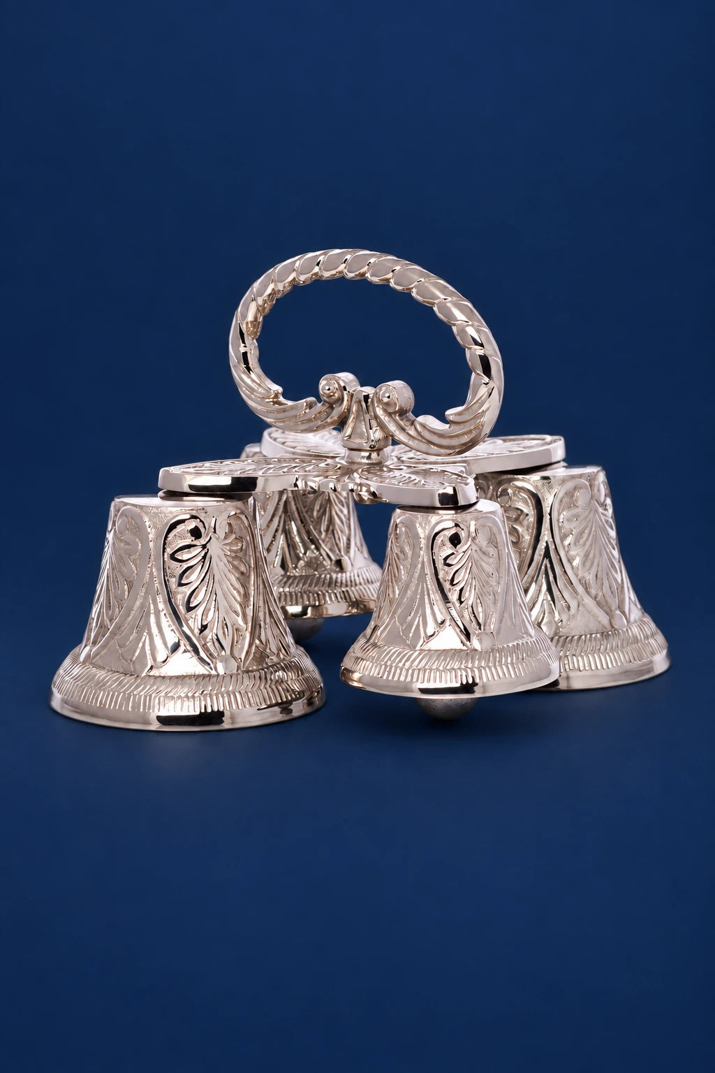 Four ornate brass sanctus bells with nickel finish and twisted handle, front view