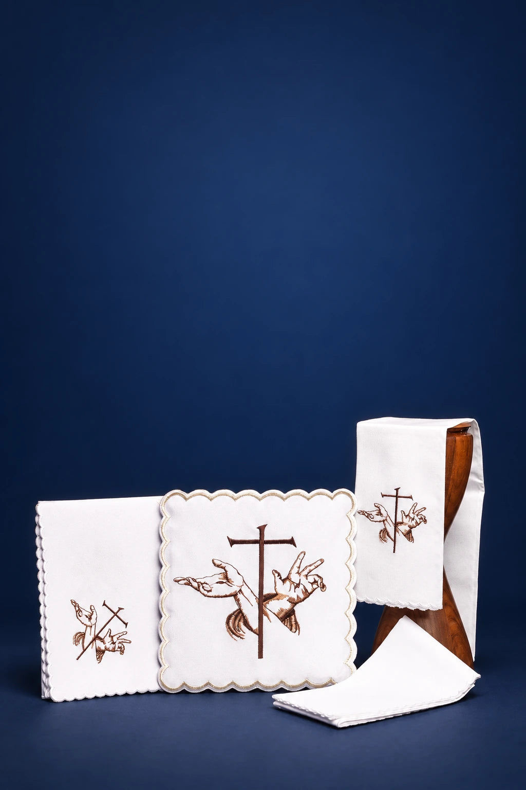 Front view of altar linen set with scalloped cloths and Franciscan cross-and-hands embroidery