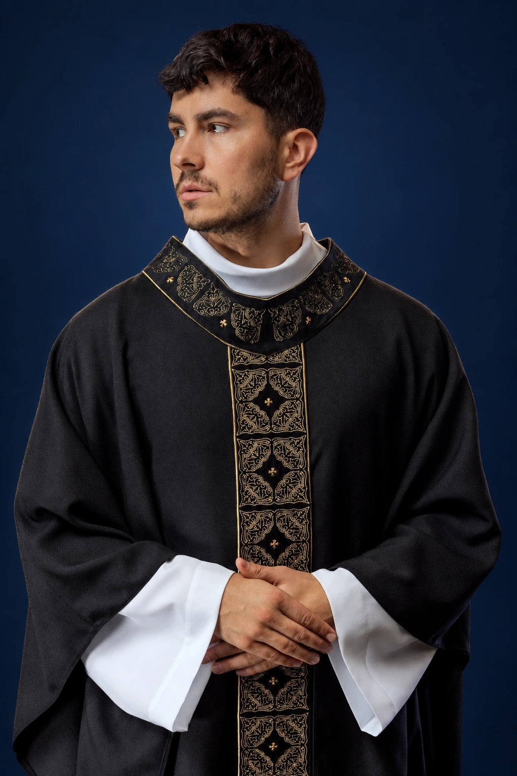 Front view of a black chasuble with a richly embroidered central orphrey and matching embroidered collar.