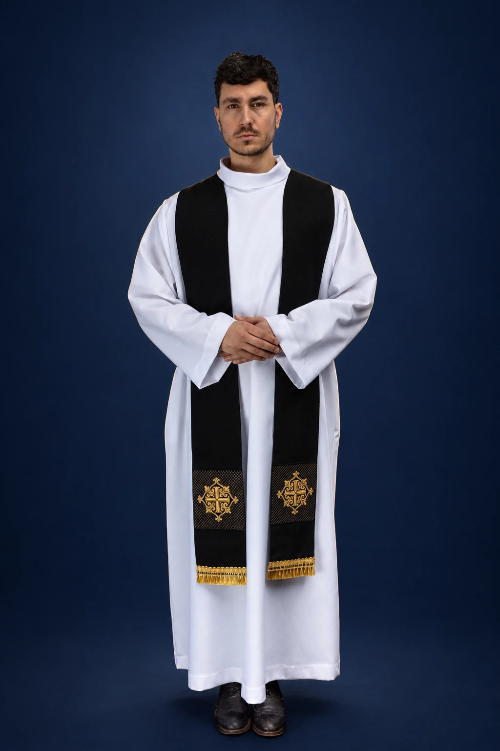 Front view of a black velvet stole with gold cross embroidery and fringe worn over a white alb