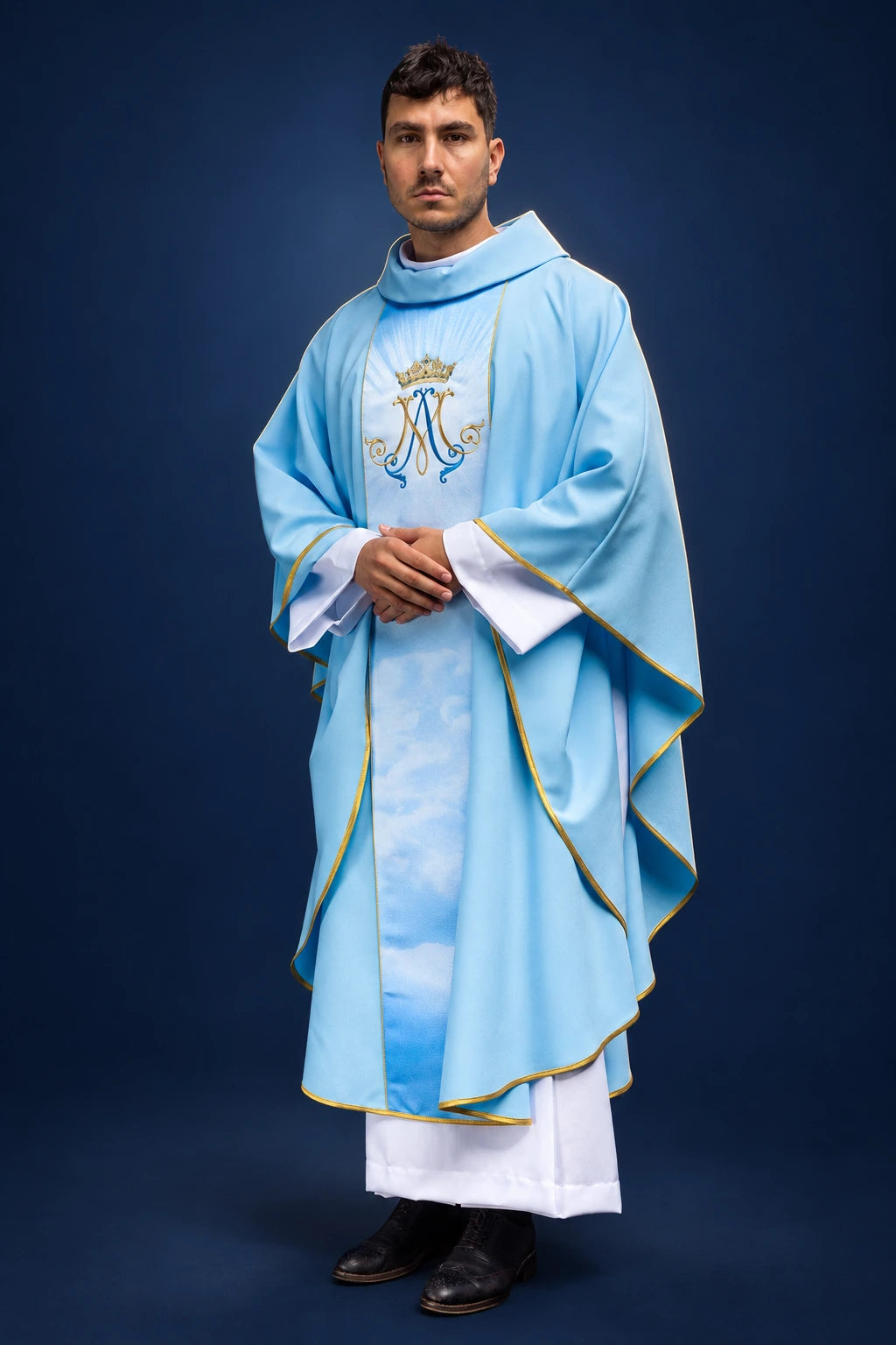 Front view of a blue Marian chasuble with gold trim, cloud panel, and embroidered Marian monogram on the chest