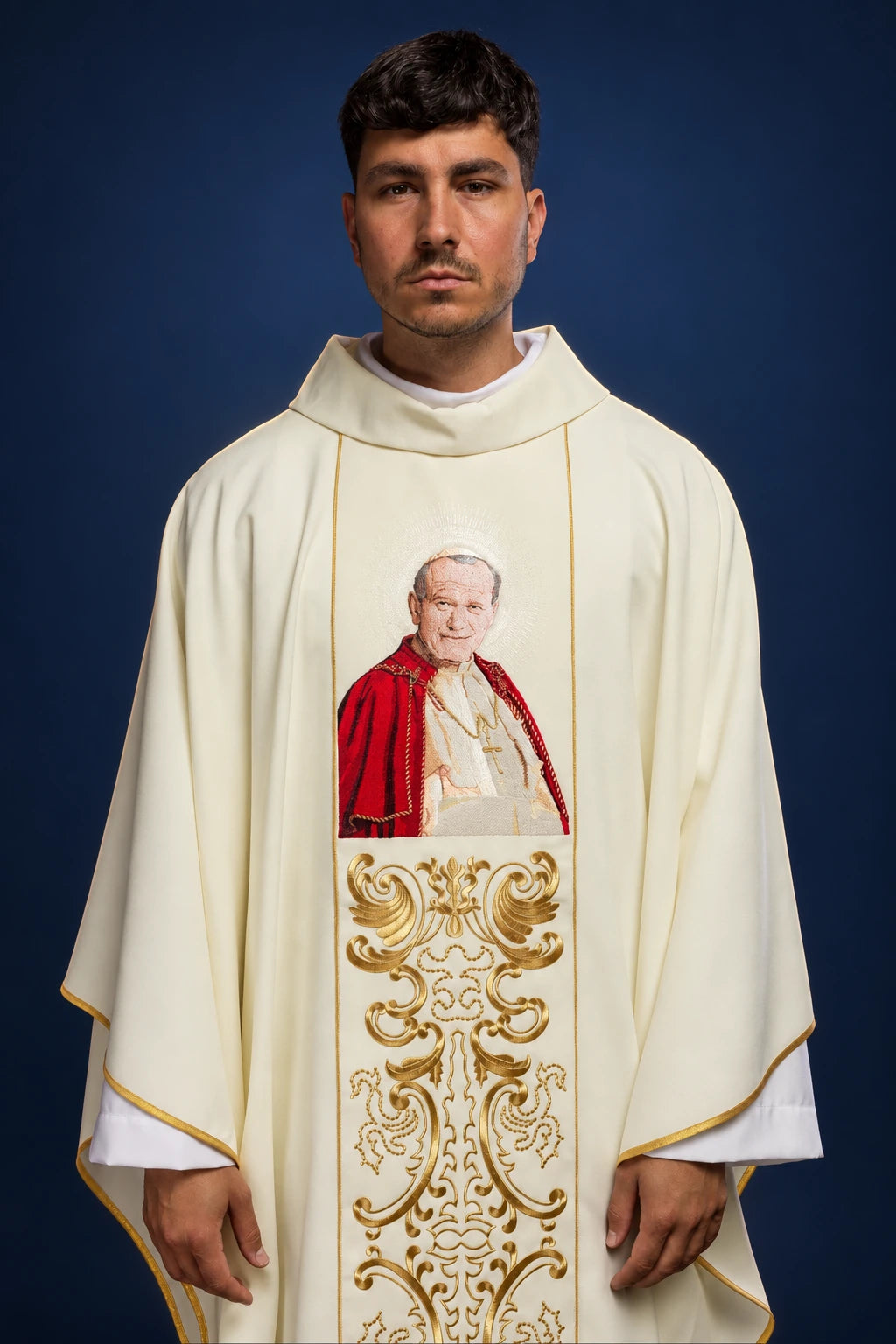 Front view of a cream chasuble with gold trim and a central image of Pope John Paul II above gold embroidery