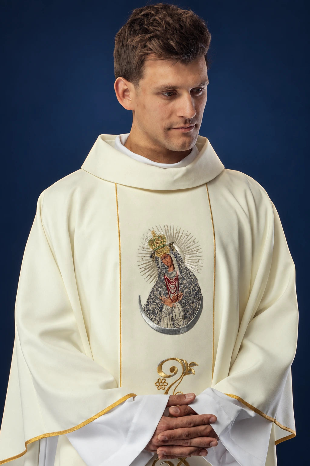 Front view of cream chasuble with gold trim and embroidered Our Lady of the Gate of Dawn medallion