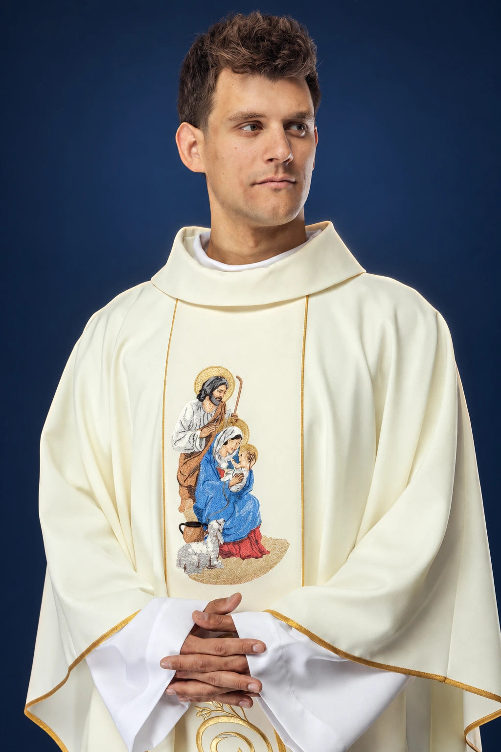 Front view of a cream chasuble with gold trim and a Holy Family embroidery on the chest