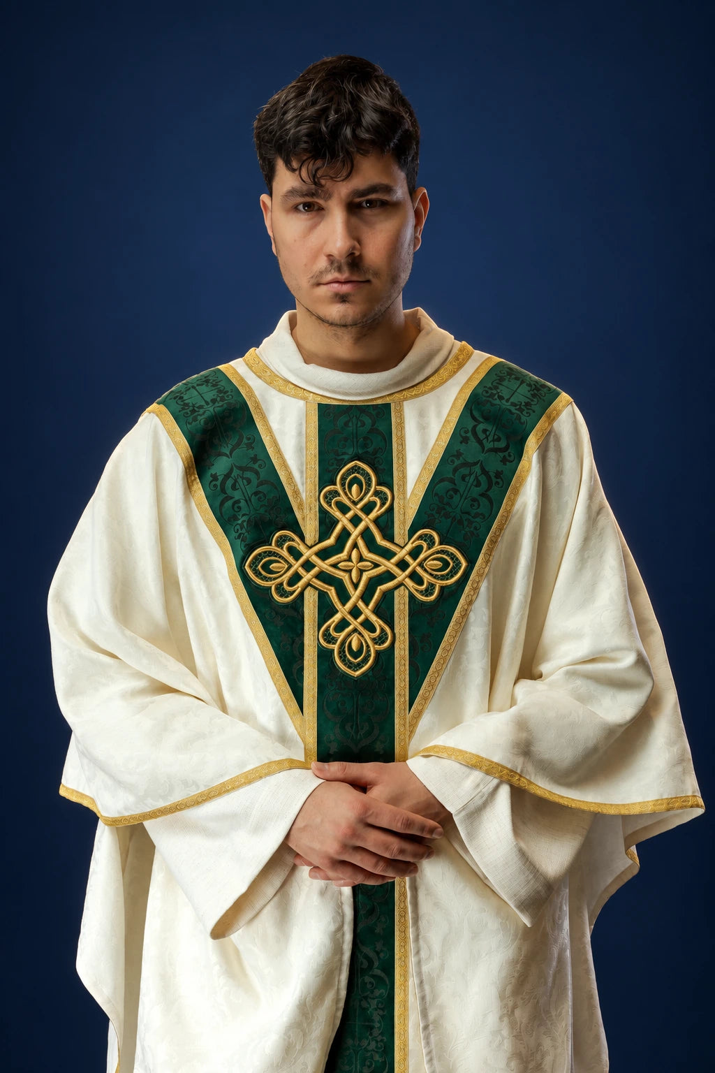 Front view of a cream chasuble with a green velvet orphrey and gold cross embroidery