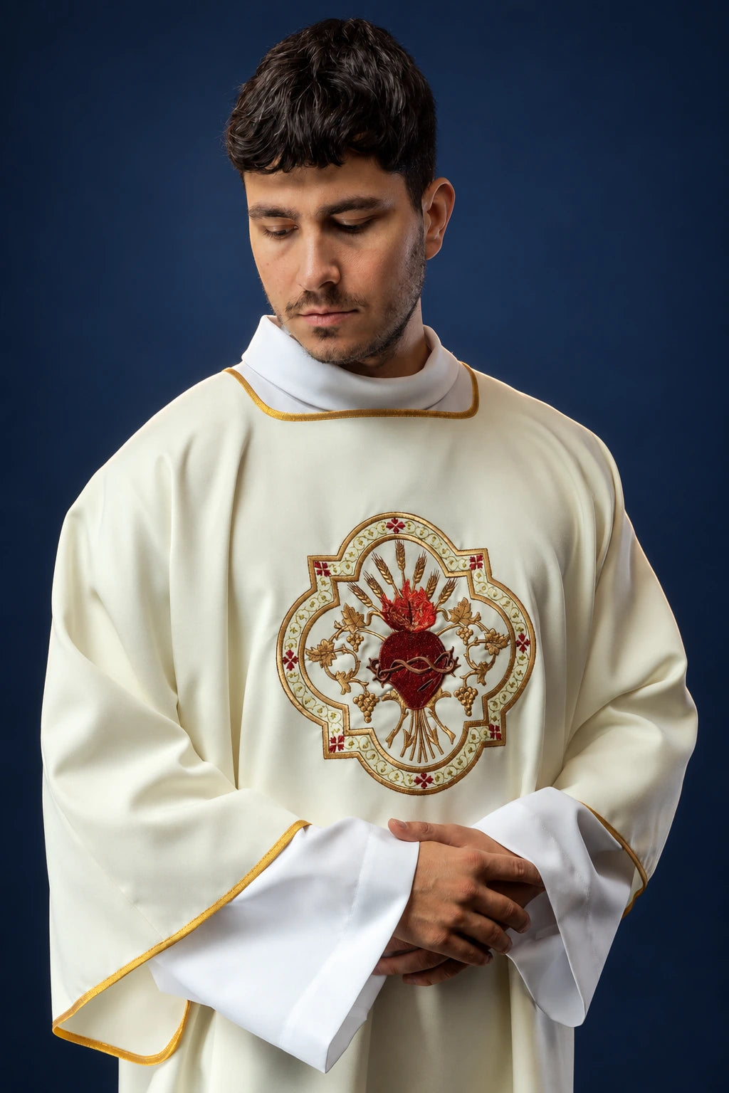 Front view of a cream dalmatic with wide sleeves and Sacred Heart emblem on the chest