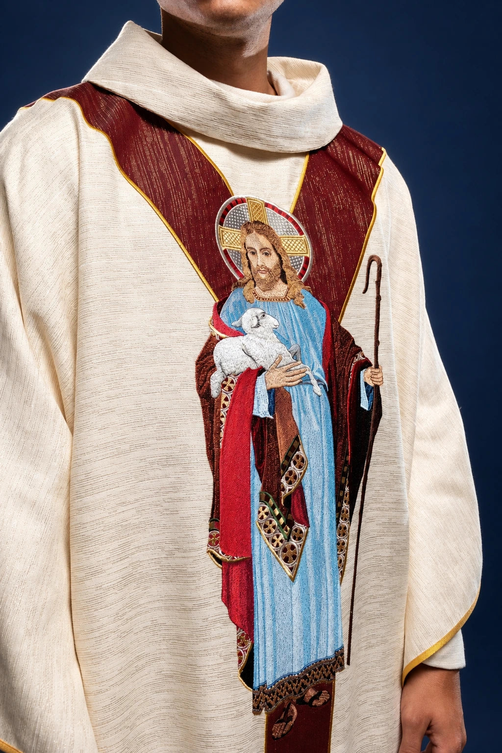 Front view of an ecru chasuble with burgundy orphrey and Good Shepherd embroidery