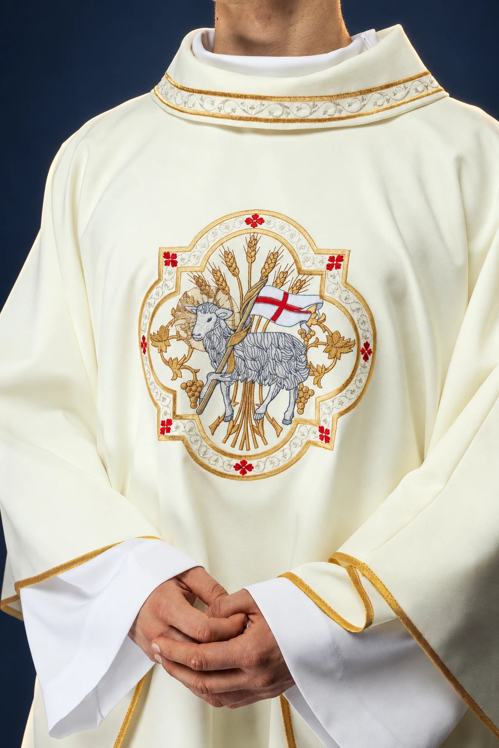 Front view of an ecru chasuble with embroidered Agnus Dei medallion and gold trim on the collar and sleeves