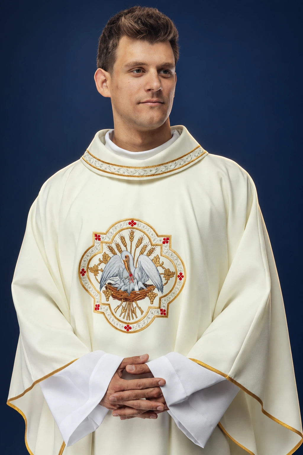 Front view of ecru chasuble with embroidered pelican motif and gold trim on the collar and hem