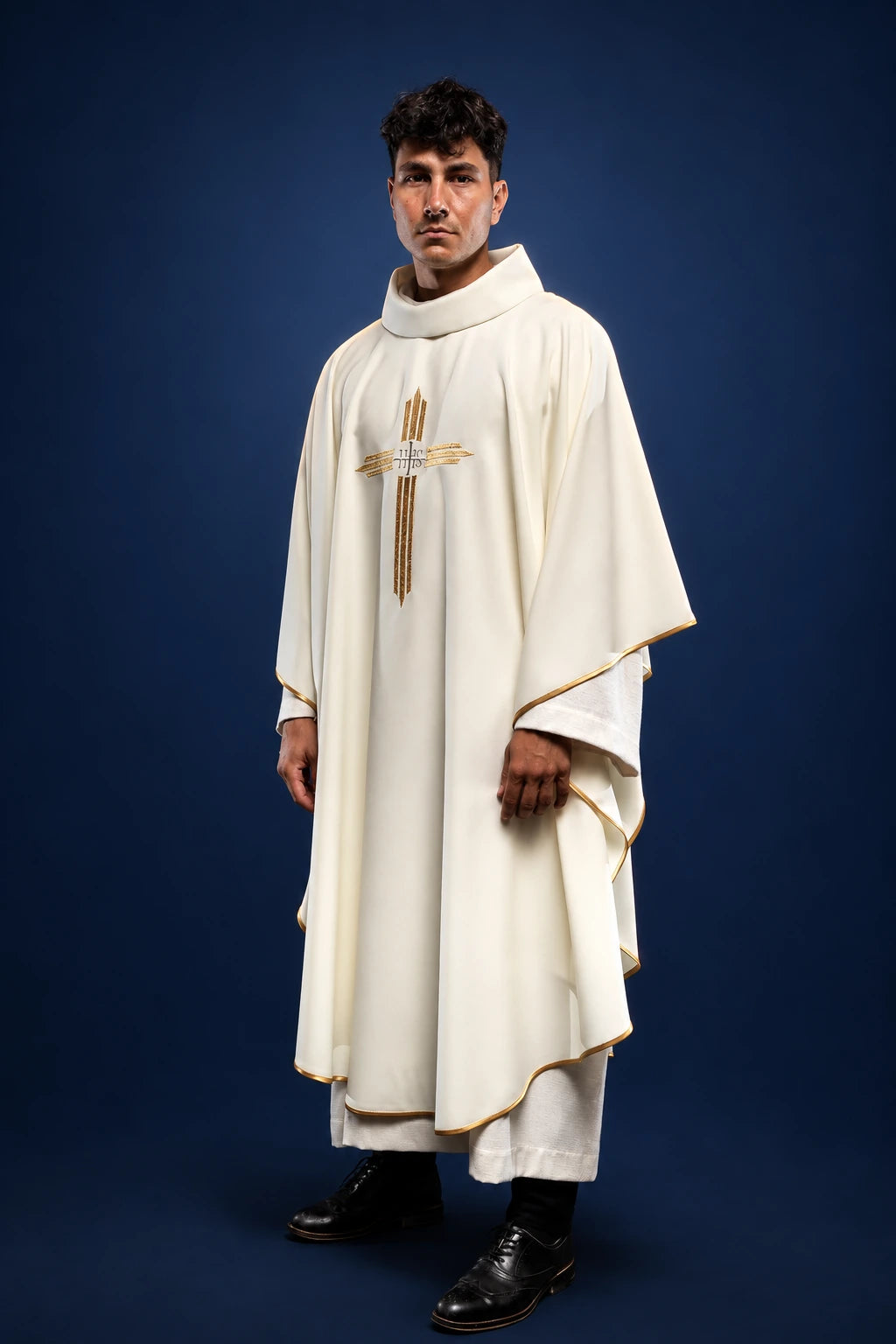 Front view of an ecru chasuble with gold trim and central cross and IHS embroidery