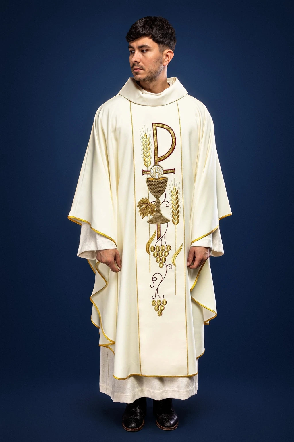 Front view of an ecru chasuble with gold trim and central IHS chalice embroidery