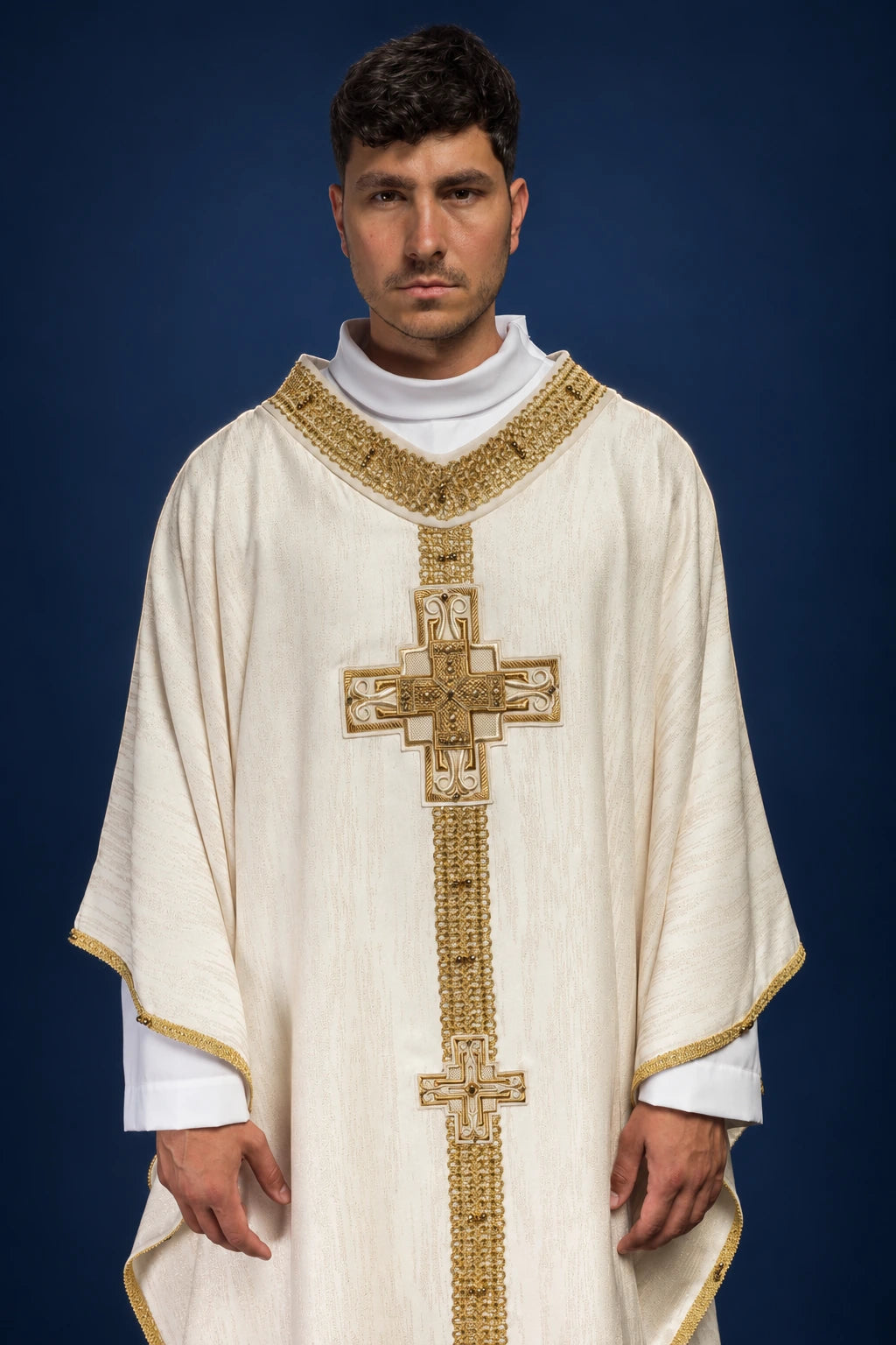 Front view of ecru chasuble with gold trim and a vertical cross pattern of natural stones