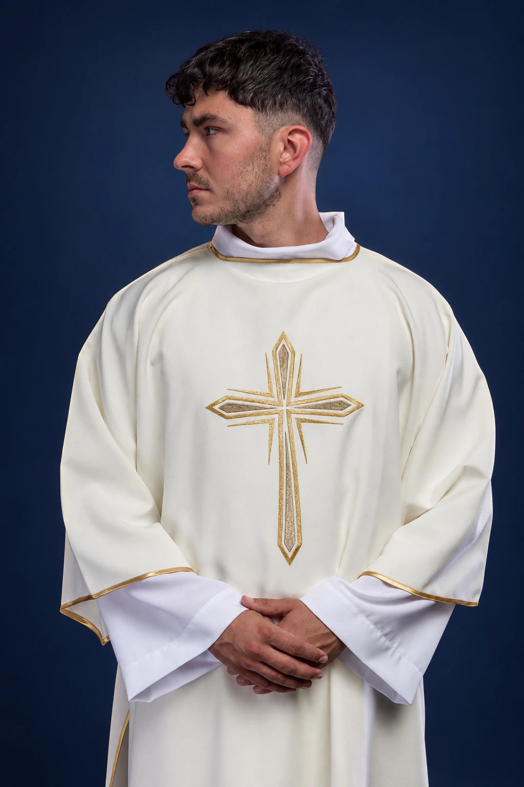 Front view of an ecru dalmatic with embroidered gold cross and gold trim at the sleeves and hem