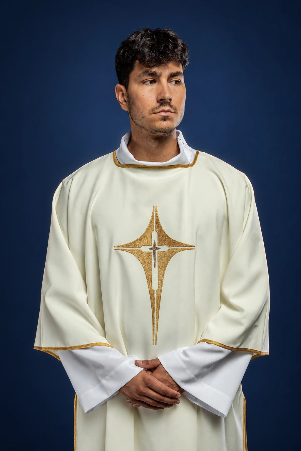 Front view of an ecru dalmatic with wide sleeves and embroidered gold cross on the chest