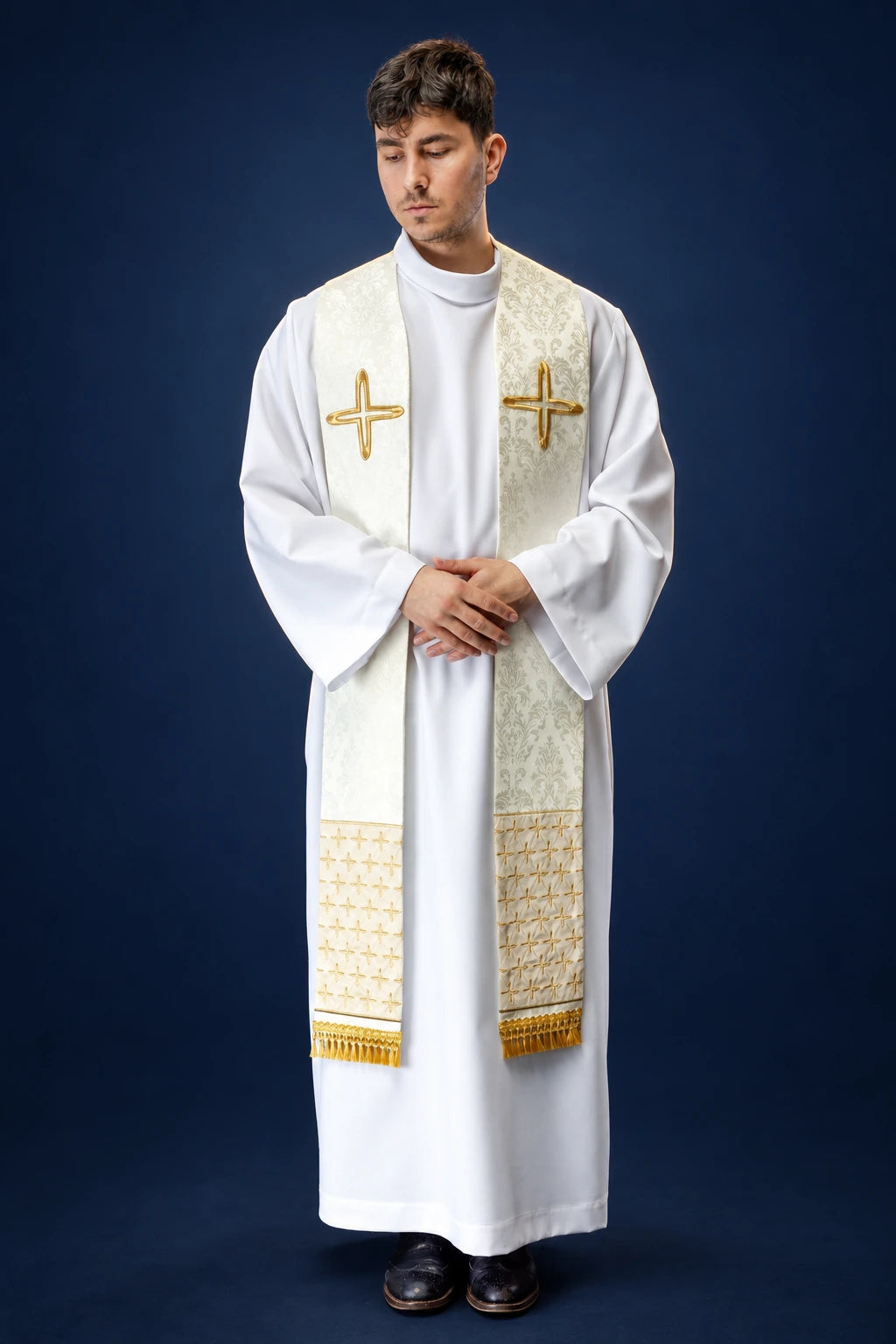Front view of an ecru jacquard stole with gold cross motifs and fringe, worn over a white alb