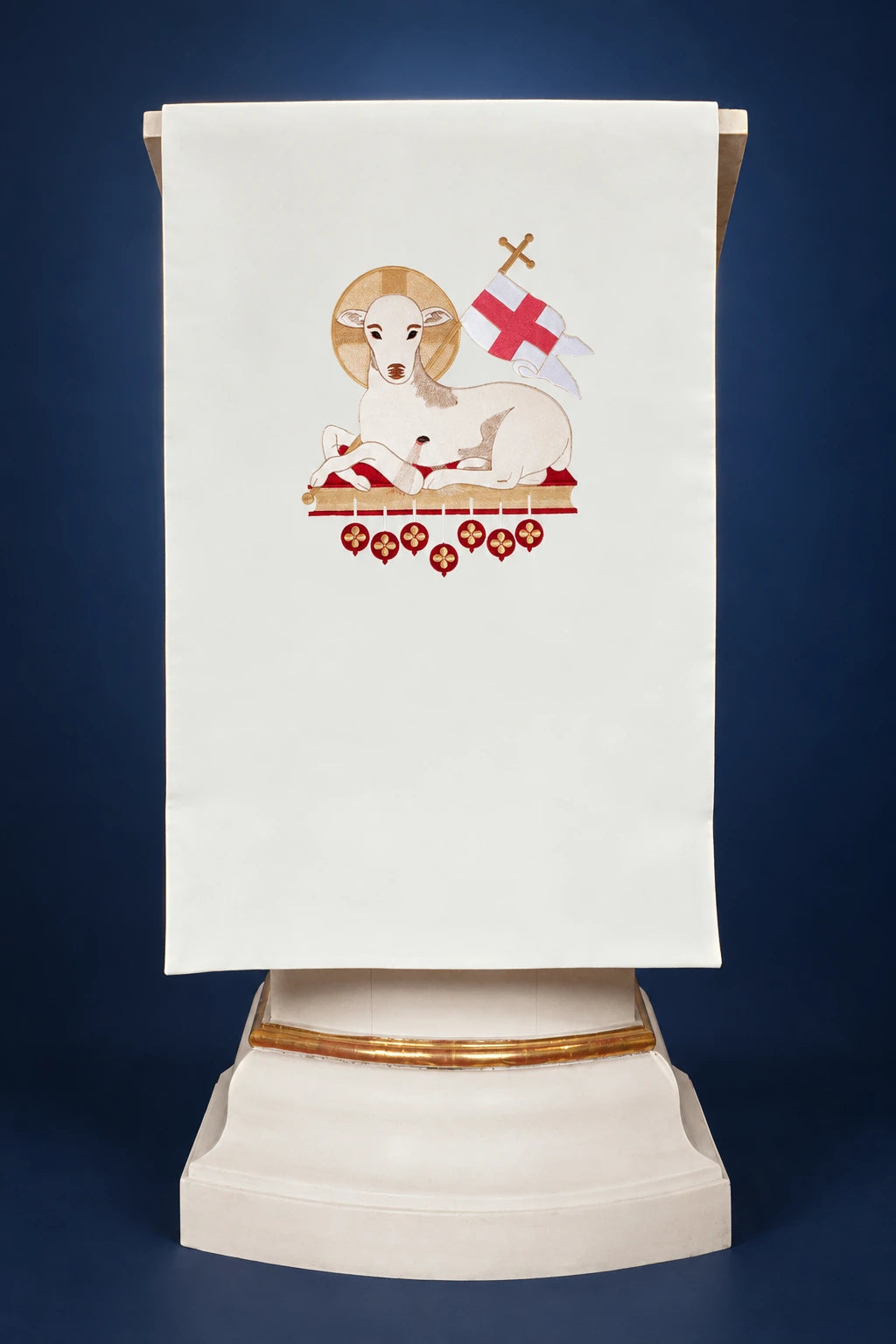 Front view of an ecru lectern cover with embroidered lamb and cross emblem on the center panel
