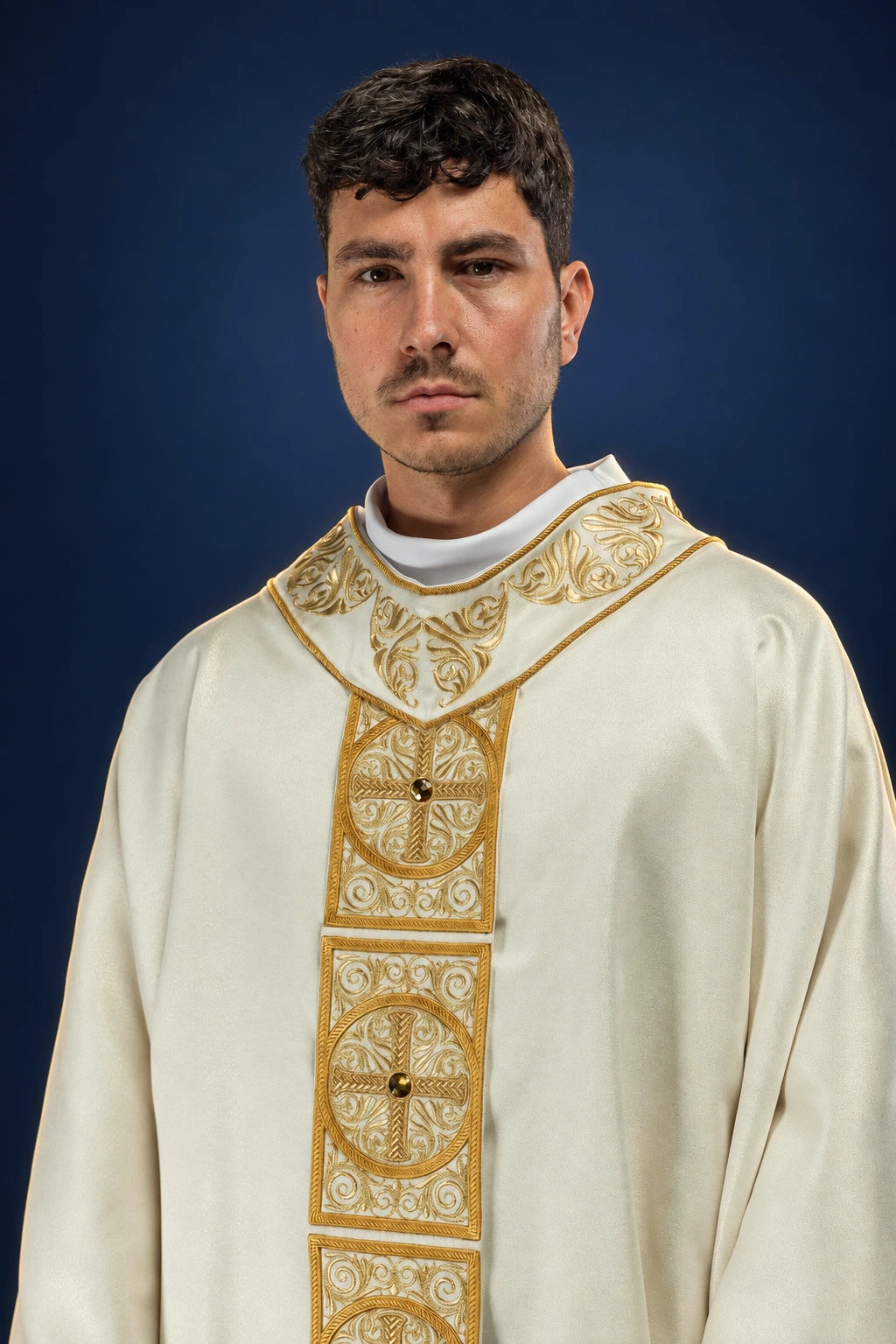 Front view of a gold chasuble with ornate embroidered orphrey and faceted stone accents on the chest and panels