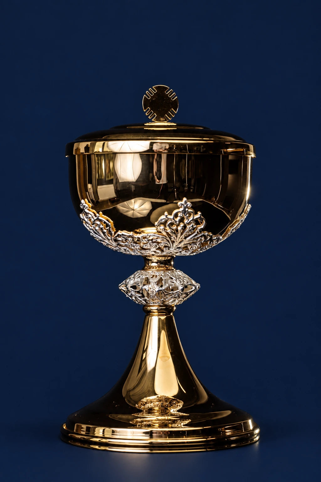 Front view of a gold-plated brass ciborium with silver floral decorations and lid cross finial