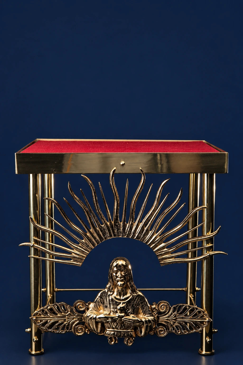 Front view of a gold-plated brass thabor table with red top and radiant Christ emblem centerpiece