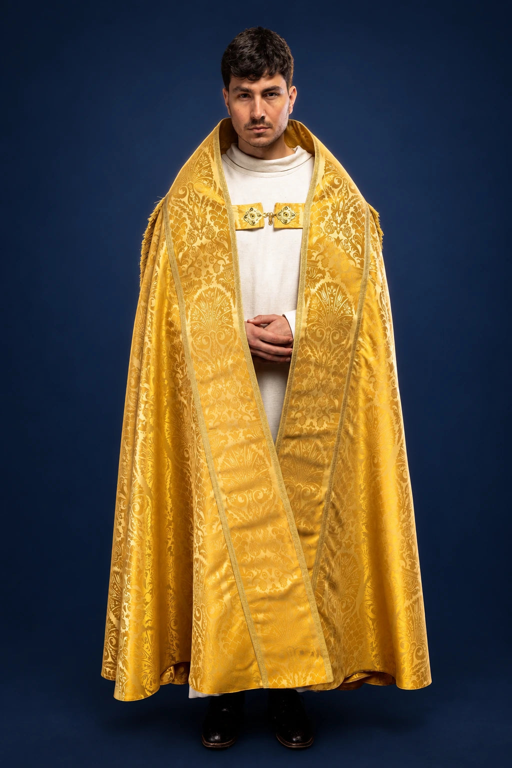 Front view of a gold Roman jacquard cope with ornate woven floral pattern and clasp at the chest