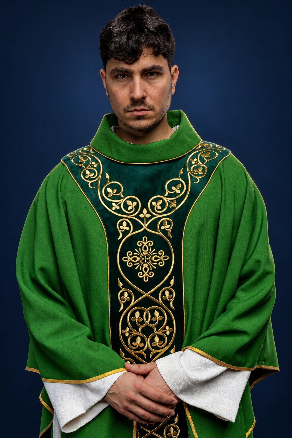 Front view of a green chasuble with black velvet orphrey and gold scroll embroidery