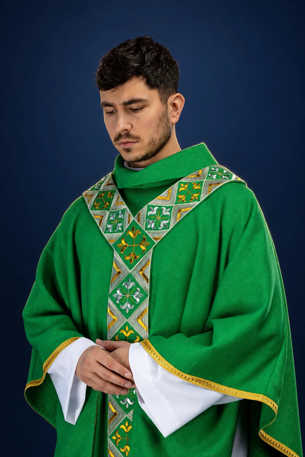 Front view of a green chasuble with embroidered orphrey and gold-trimmed sleeves over white vestments