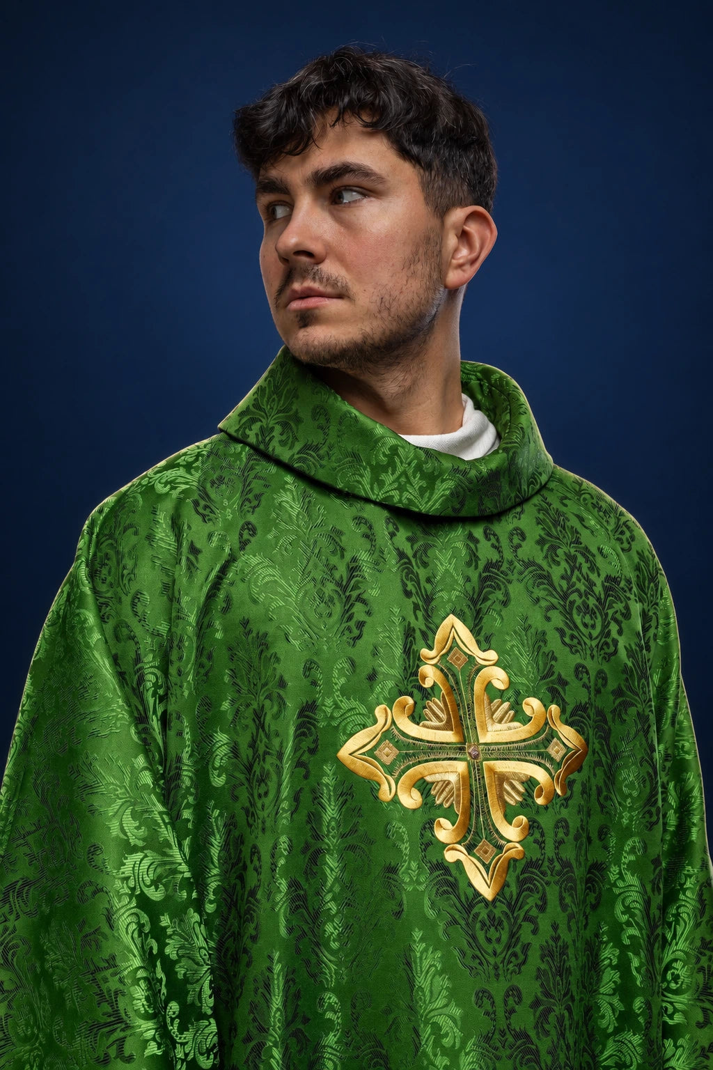 Front view of green chasuble with gold embroidered cross and subtle damask pattern