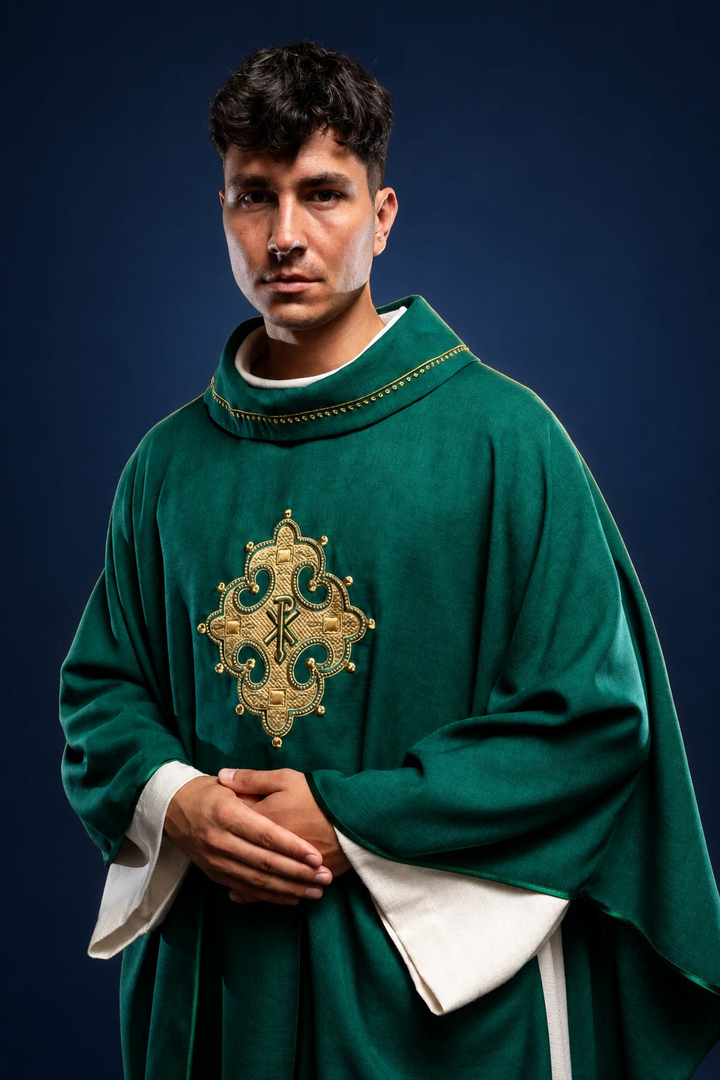 Front view of a green chasuble with gold embroidered cross and gold trim on the collar