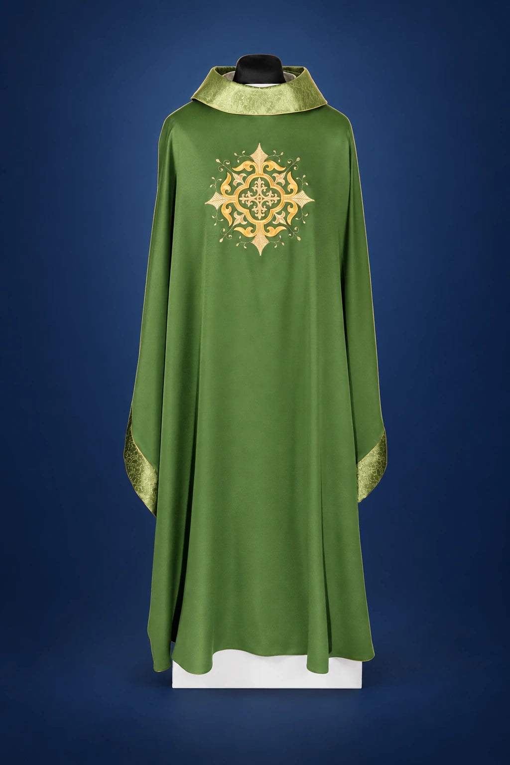 Front view of a green chasuble with gold satin trim and an ornate embroidered cross on the chest