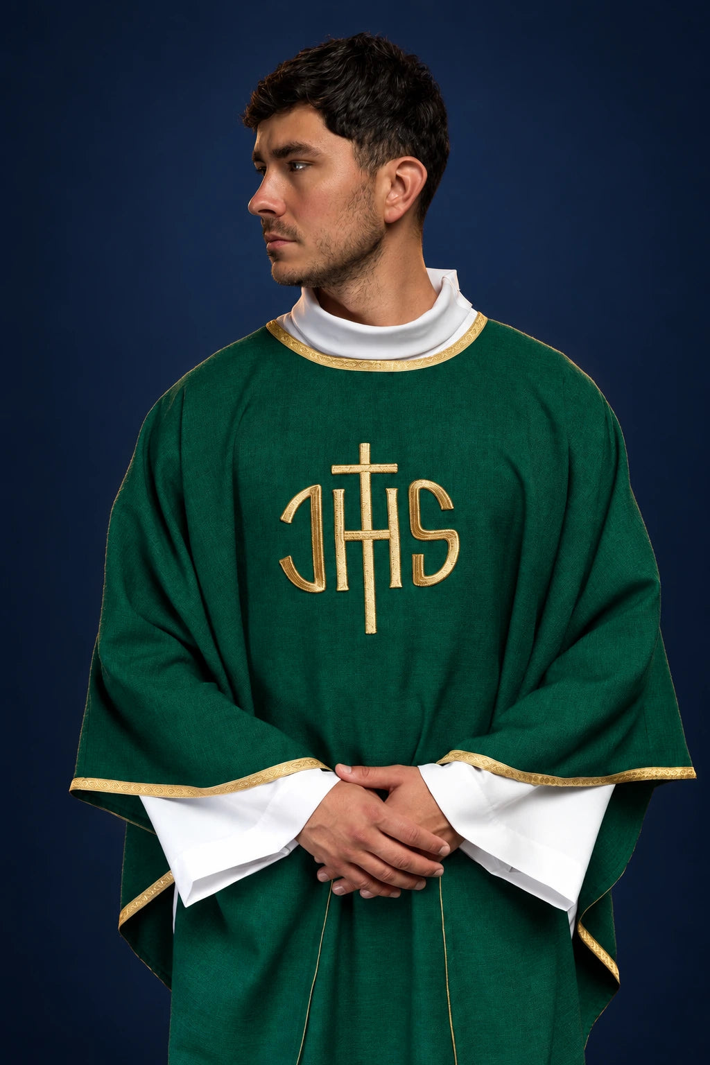 Front view of a green chasuble with gold trim and large gold IHS embroidery on the chest