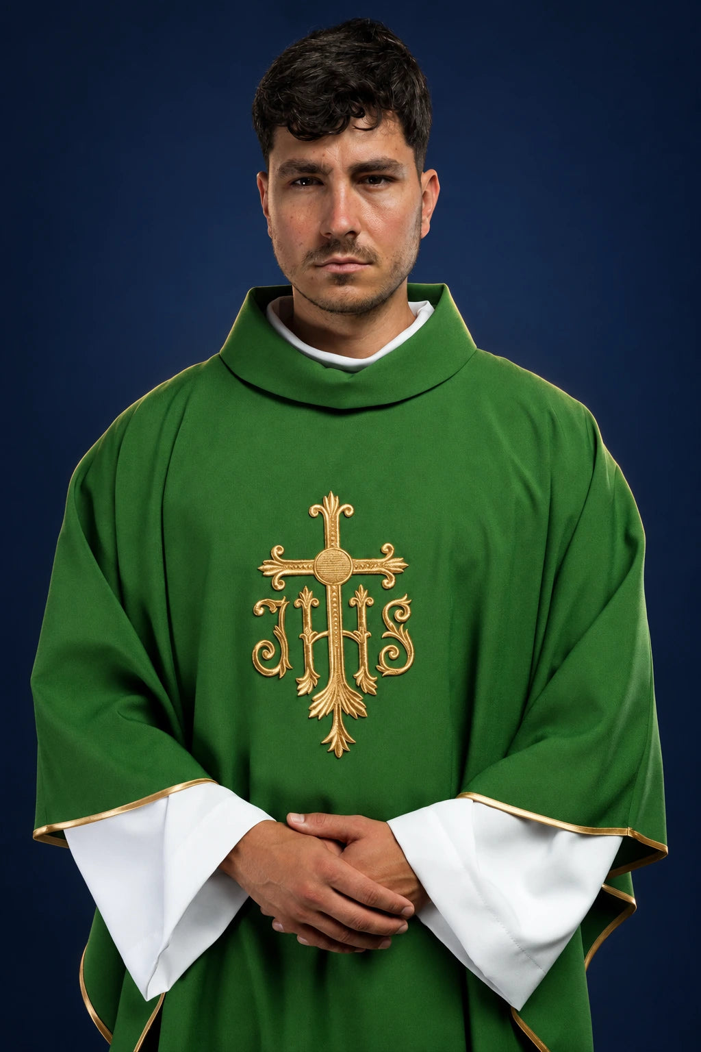 Front view of a green chasuble with raised gold JHS embroidery and gold-edged sleeves over a white alb