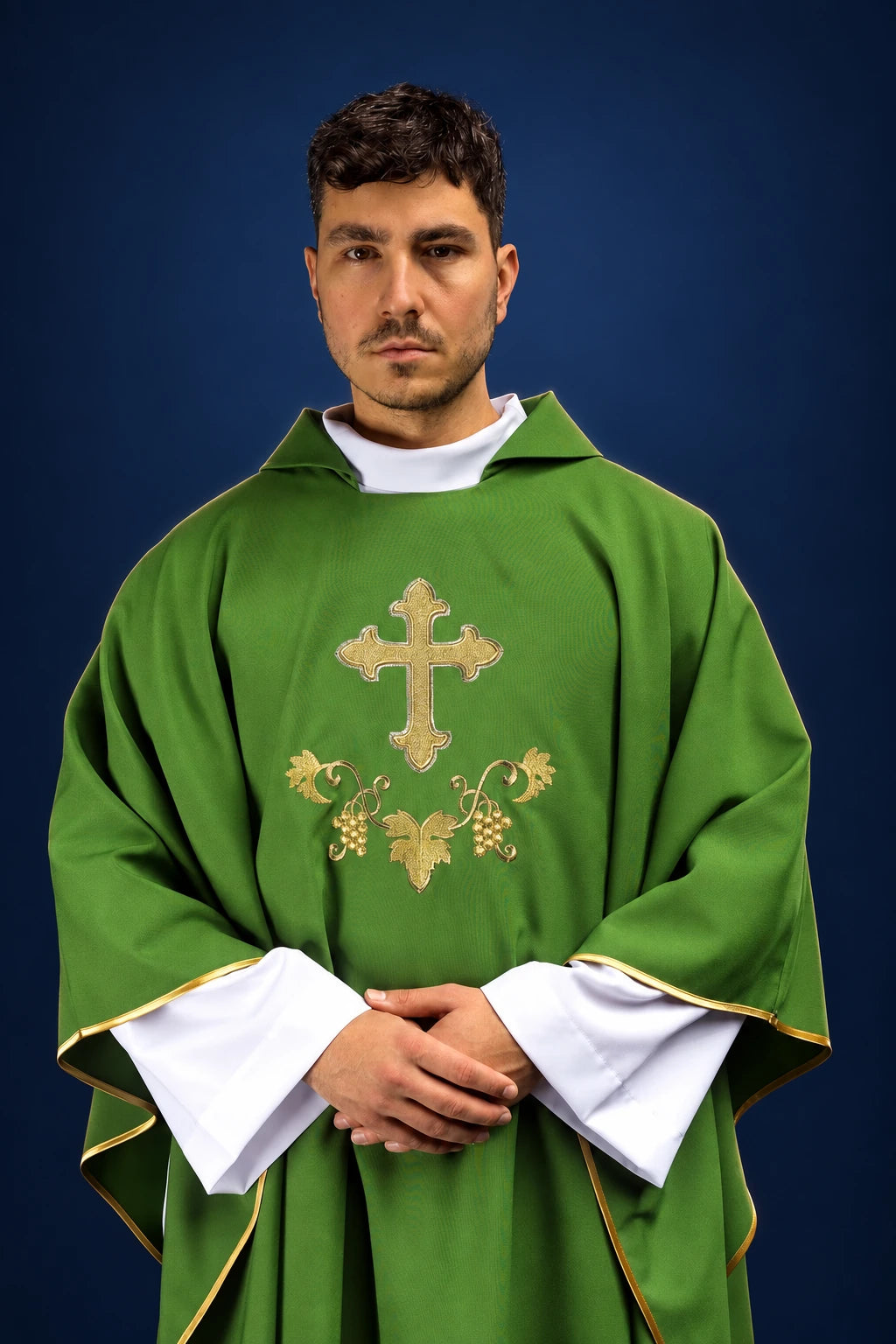 Front view of a green chasuble with wide collar, gold trim, and embroidered cross and vine motif on the chest