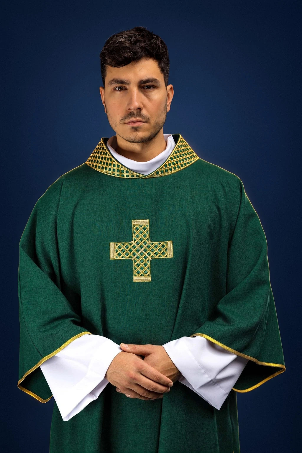 Front view of a green dalmatic with gold embroidered cross and patterned collar, worn over white sleeves