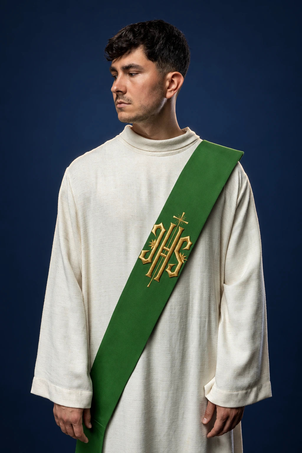 Front view of a green deacon stole with gold IHS and small cross embroidery, worn diagonally over a white alb