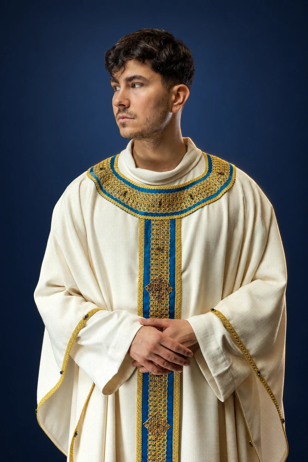 Front view of an ivory chasuble with gold and blue woven vertical and neckline bands, trimmed in gold