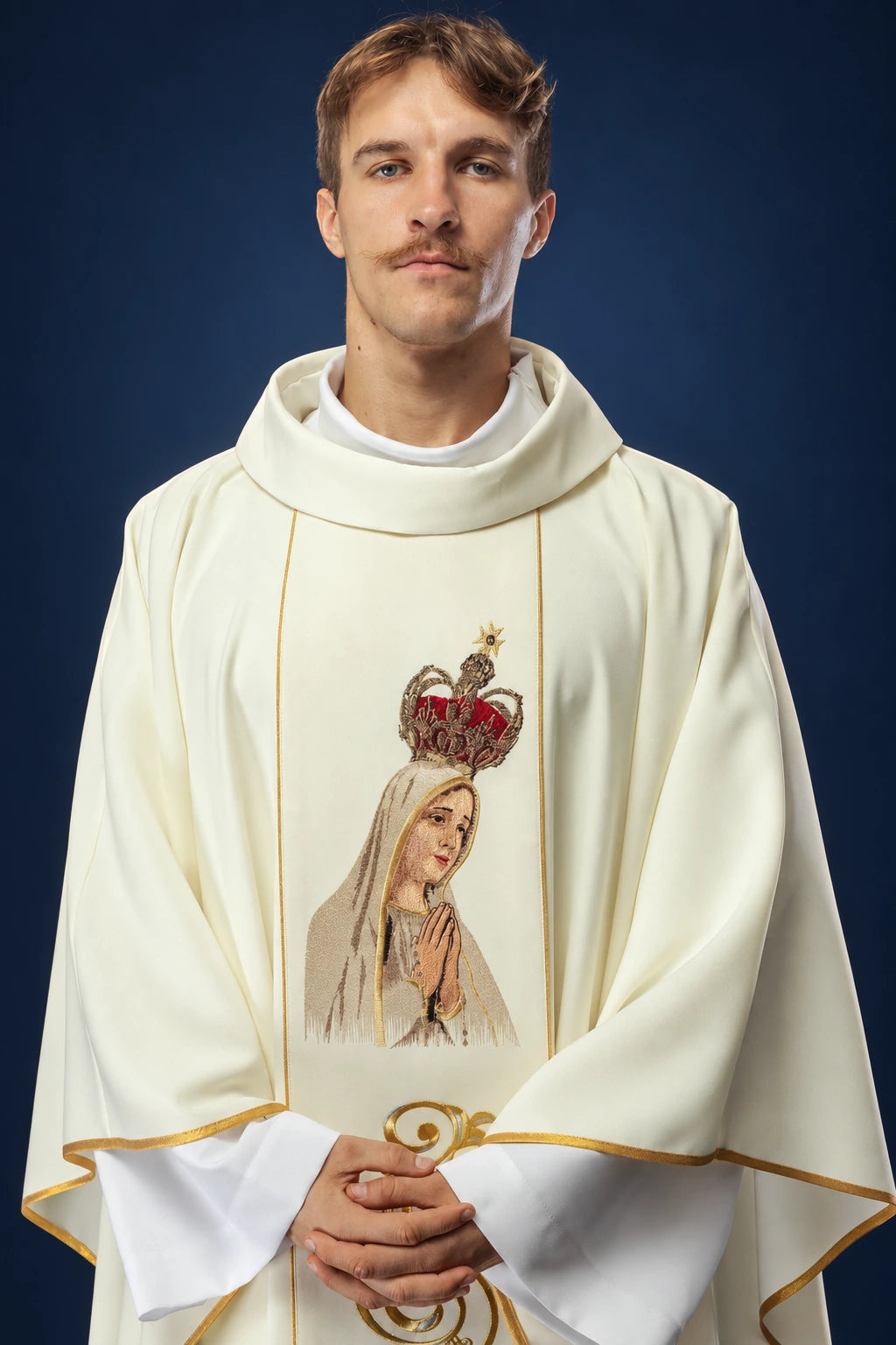 Front view of an ivory chasuble with gold trim and embroidered Our Lady of Fatima panel