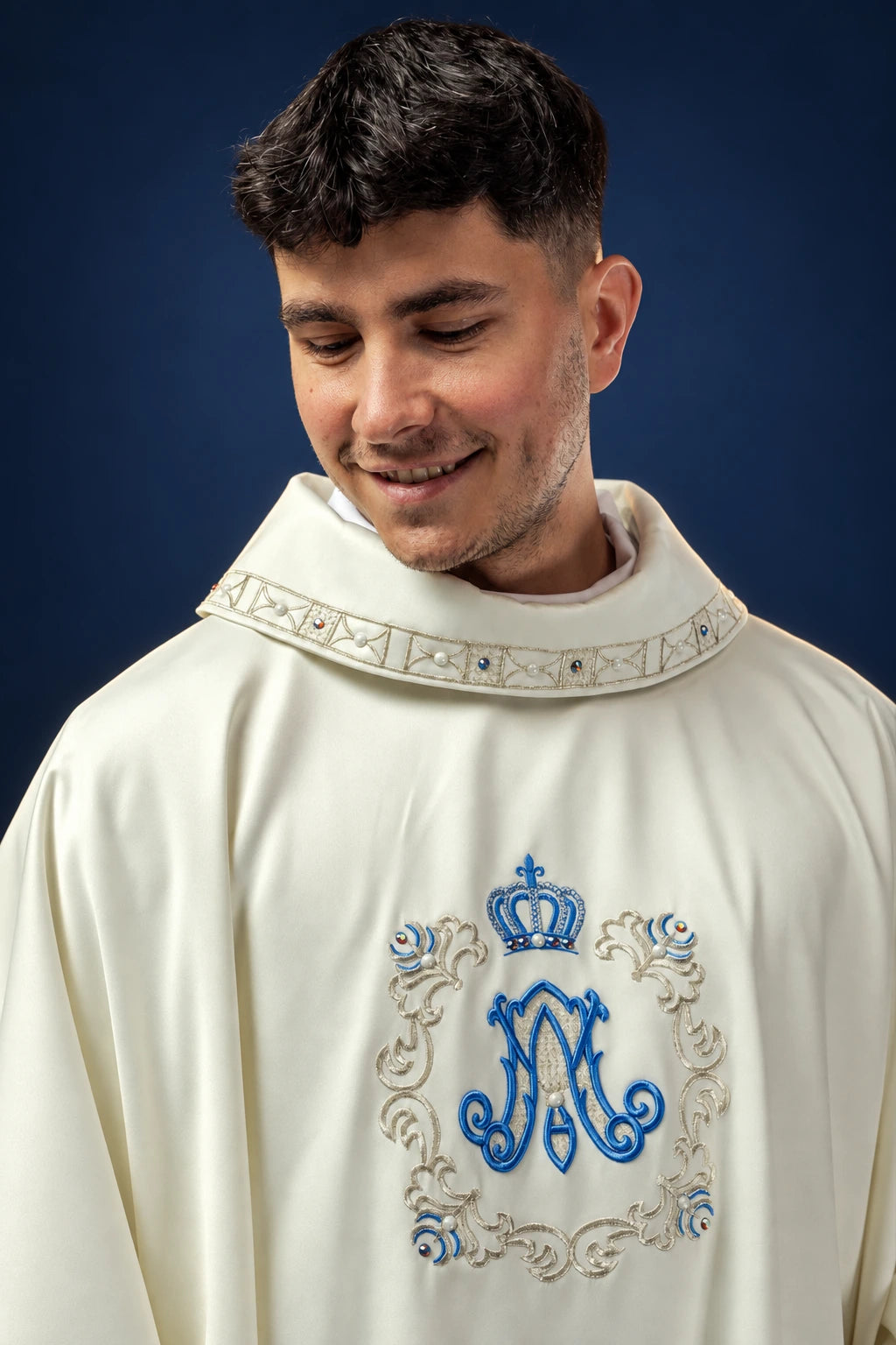 Front view of an ivory Marian chasuble with embroidered blue M and crown motif on the chest