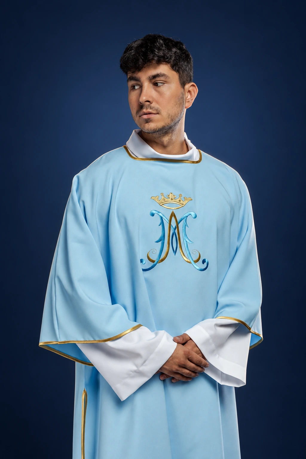 Front view of a light blue dalmatic with Marian monogram embroidery and gold trim on sleeves and collar