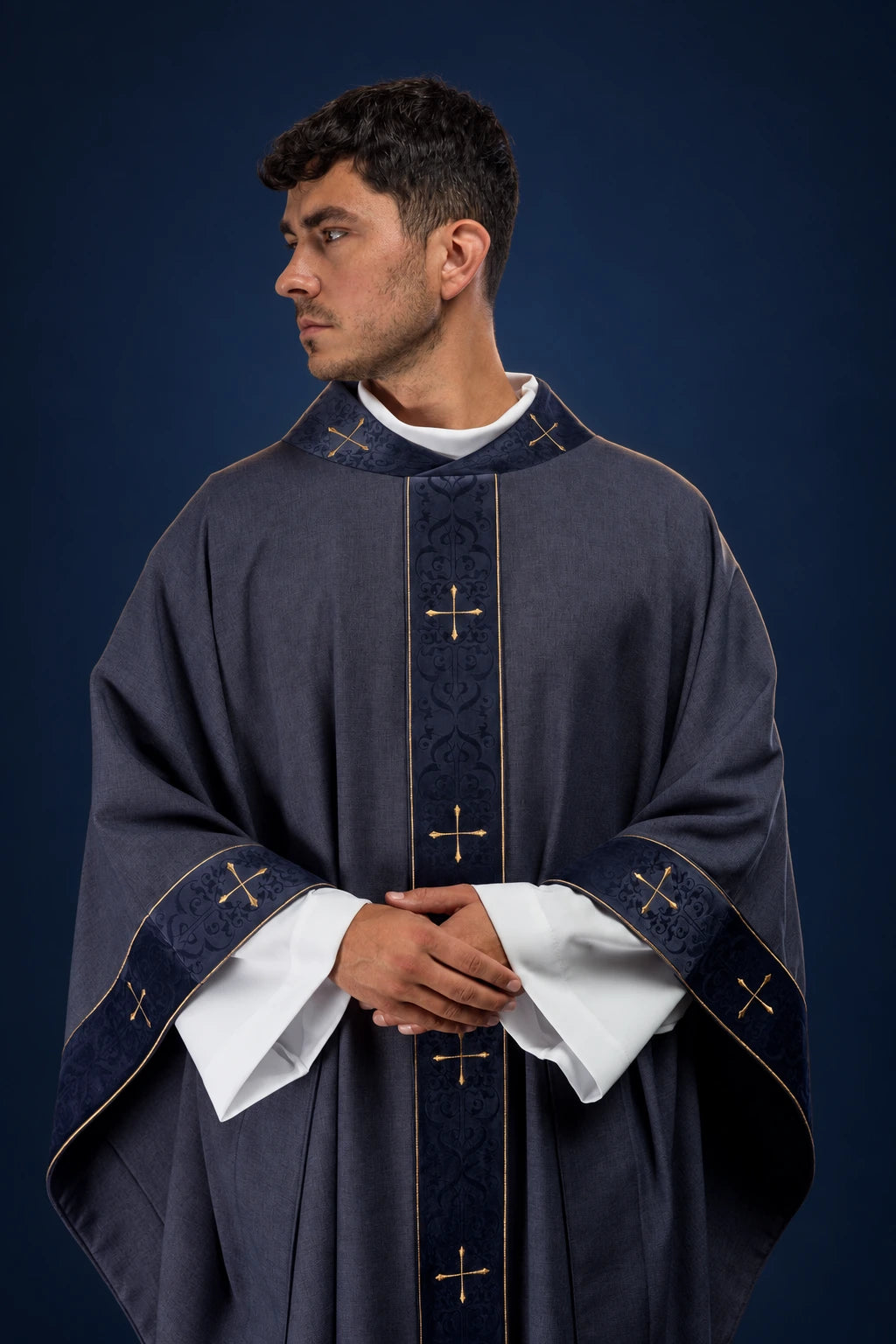 Front view of a purple chasuble with embroidered orphrey and cross-motif collar and cuffs
