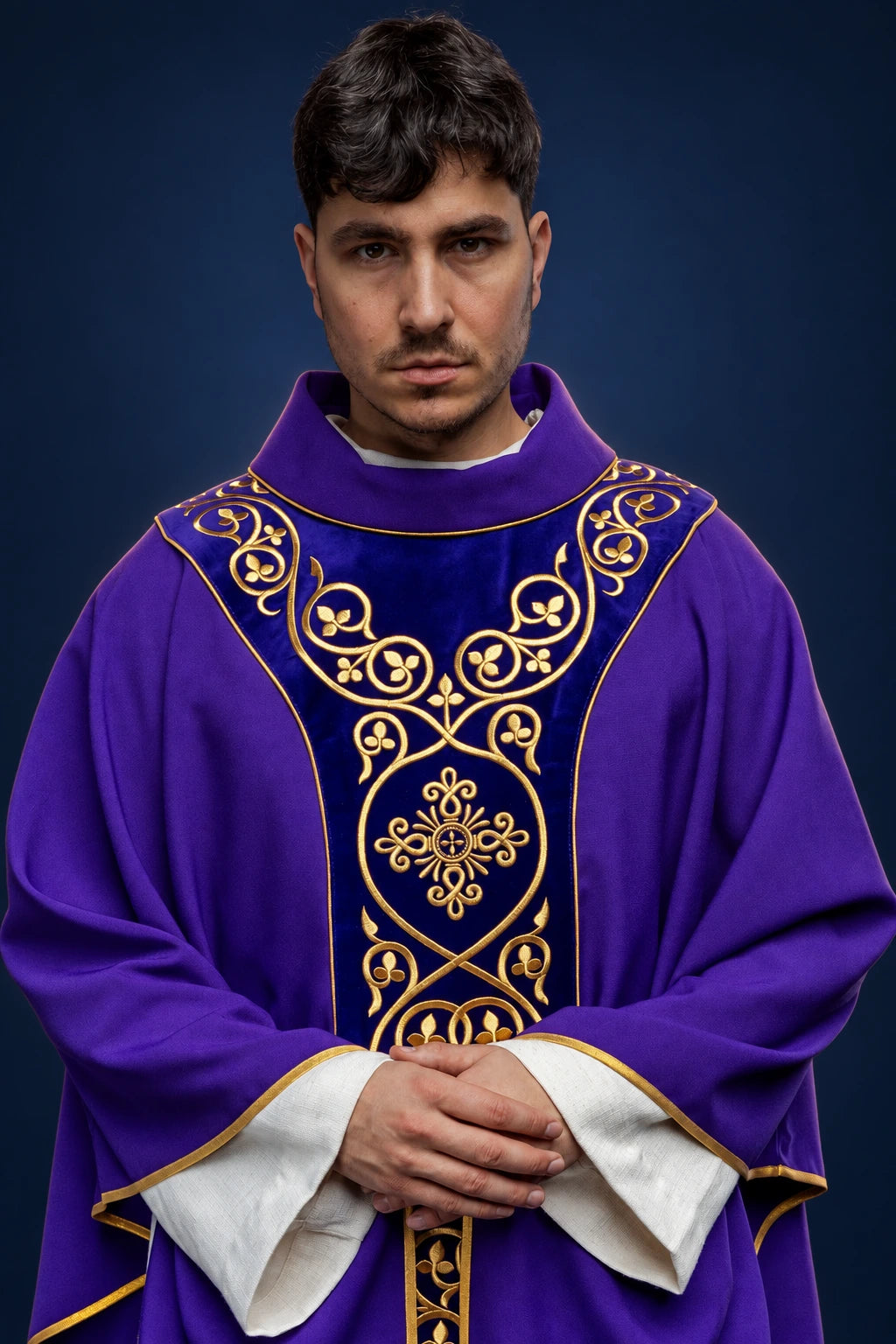 Front view of a purple chasuble with embroidered velvet orphrey and gold vine scrollwork on the chest and front panel