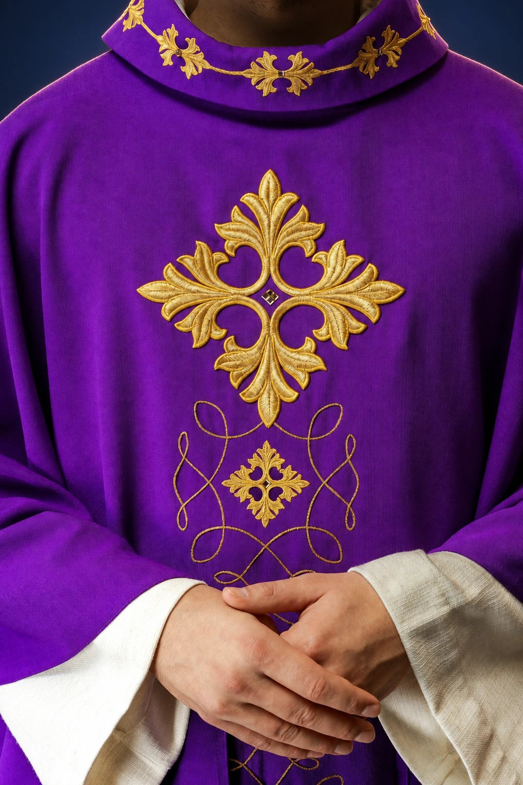 Front view of a purple chasuble with gold cord embroidery and cross motif on the chest and collar