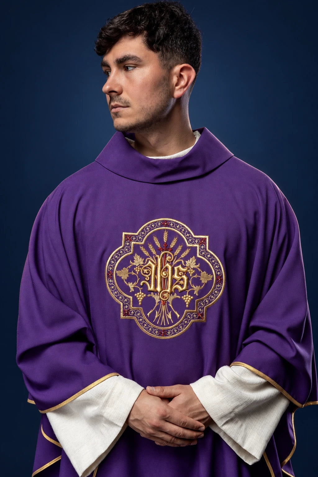 Front view of a purple chasuble with gold IHS embroidery and white sleeves trimmed in gold