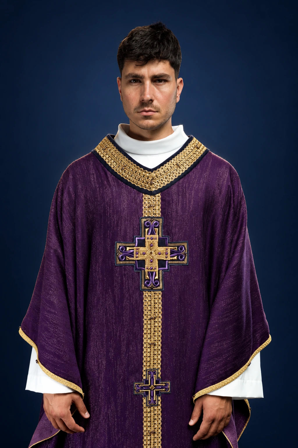 Front view of a purple chasuble with gold trim and vertical cross embroidery, worn over a white alb