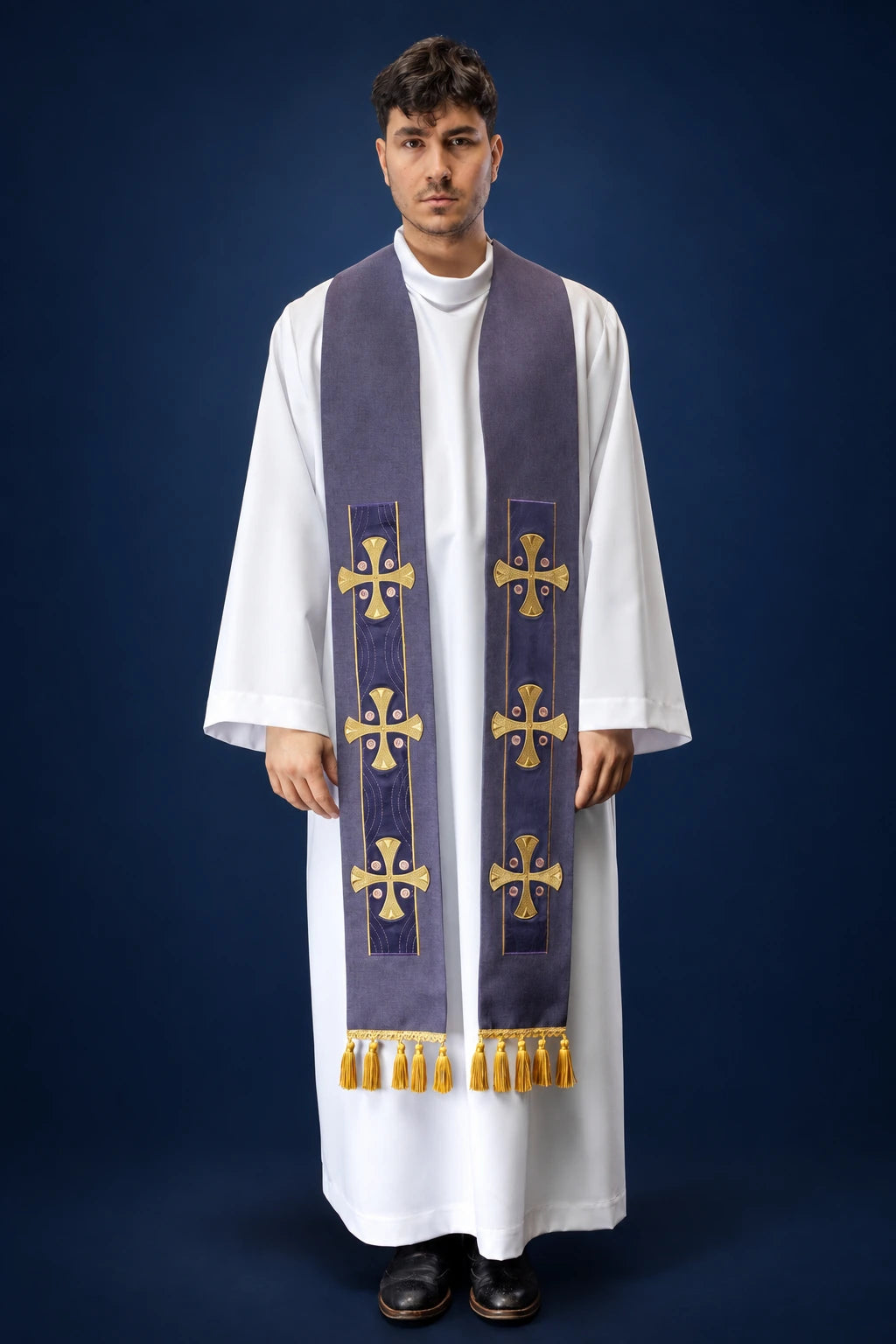 Front view of a purple stole with gold cross embroidery and fringe ends, worn over a white alb