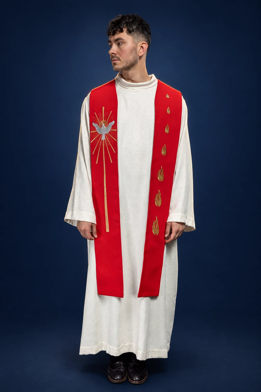Front view of a red Catholic stole with Holy Spirit and flame embroidery, worn over a white alb