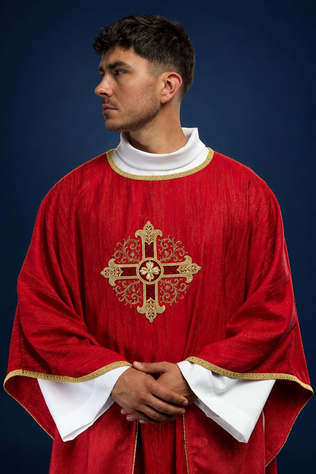 Front view of a red chasuble with gold cross embroidery and gold trim over a white alb.