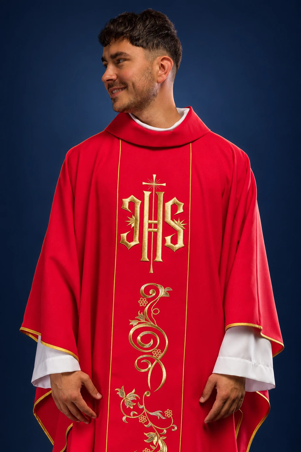 Front view of a red chasuble with gold IHS embroidery and ornate floral vine trim