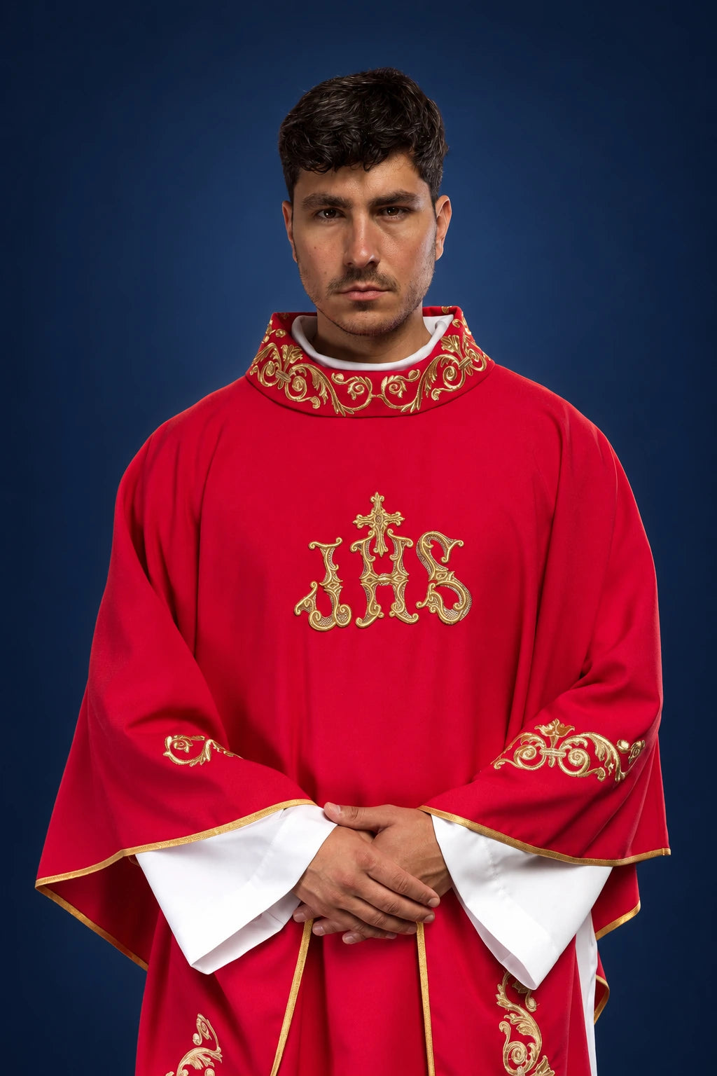 Front view of a red chasuble with gold IHS embroidery and ornate gold trim at the collar and sleeves