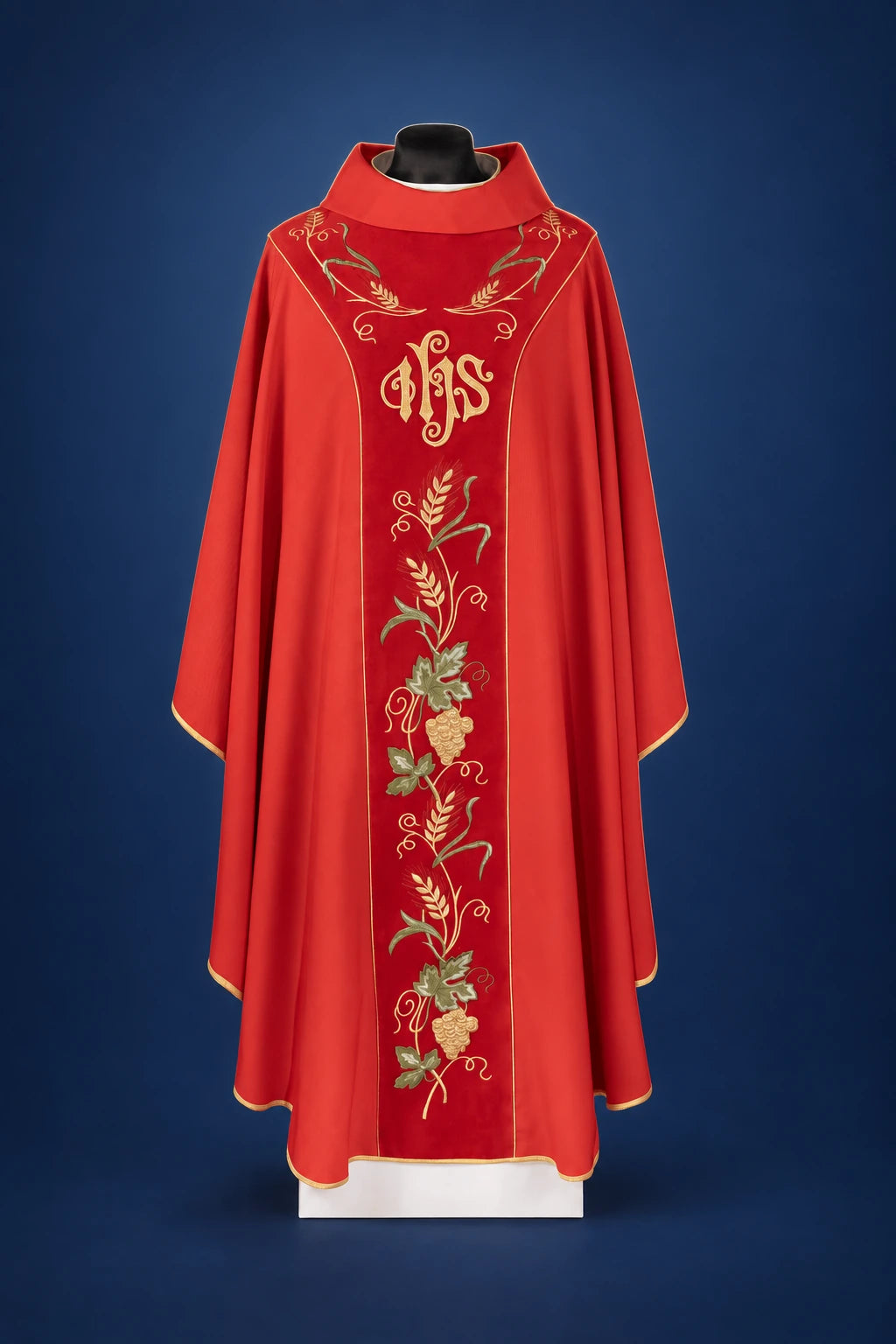 Front view of a red chasuble with gold trim, IHS embroidery, and a vertical vine-and-grape orphrey