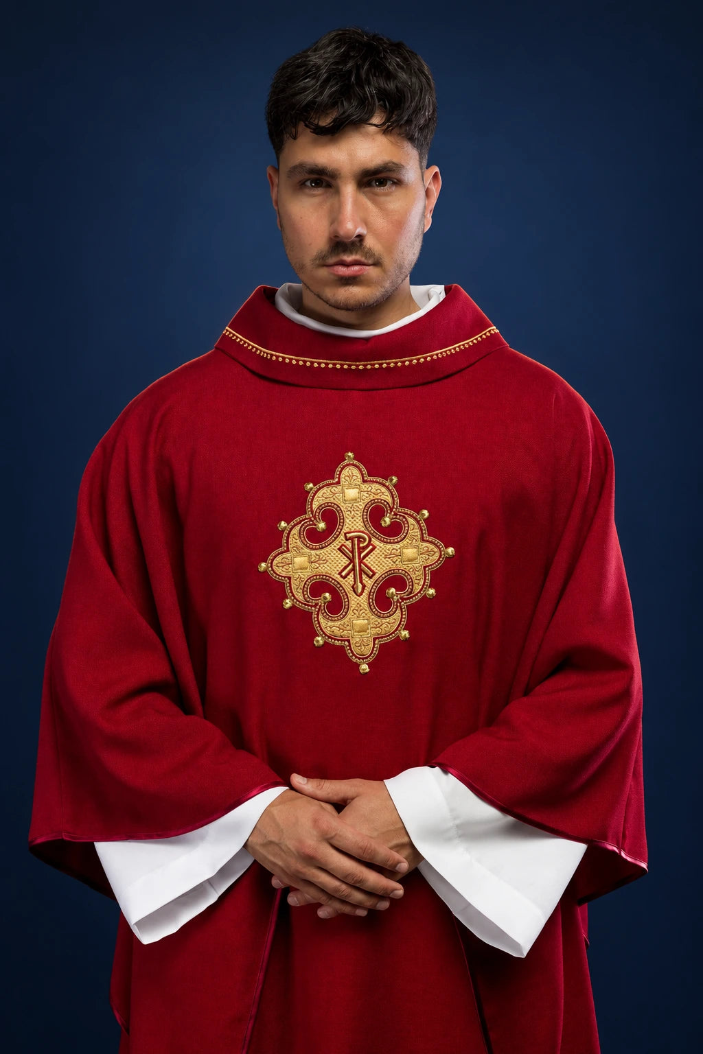 Front view of a red chasuble with gold-trimmed collar and embroidered cross medallion on the chest